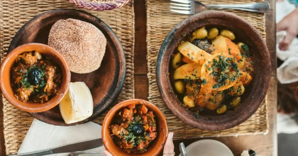 Tajine de verduras y cordero servido en platos de barro en Marruecos