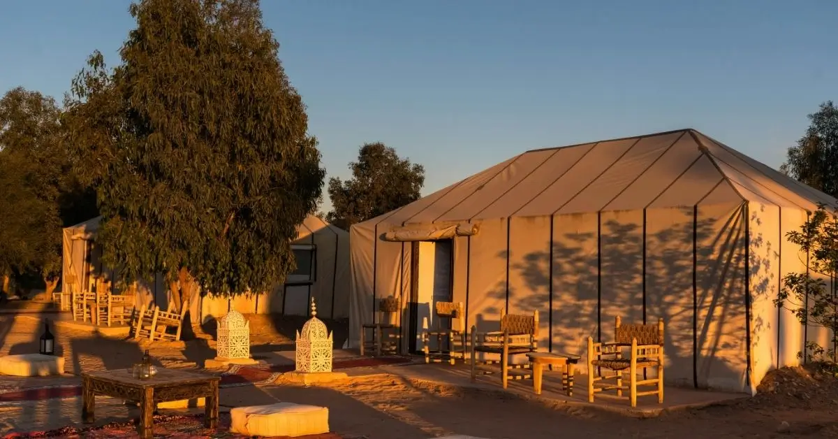 Campamento de lujo en el desierto de Marruecos al atardecer.