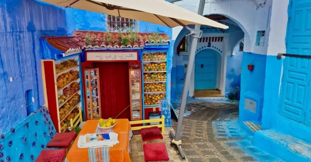 Fachadas azules y puesto de zumos en una calle de Chefchaouen, Marruecos.
