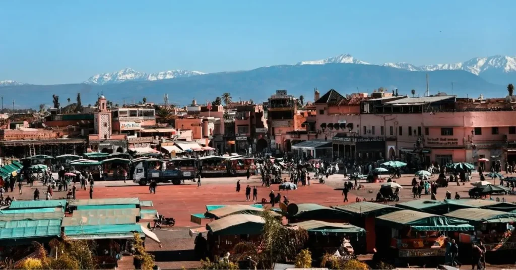 Vista panorámica de la plaza Jemaa el-Fna en Marrakech con el Atlas al fondo.