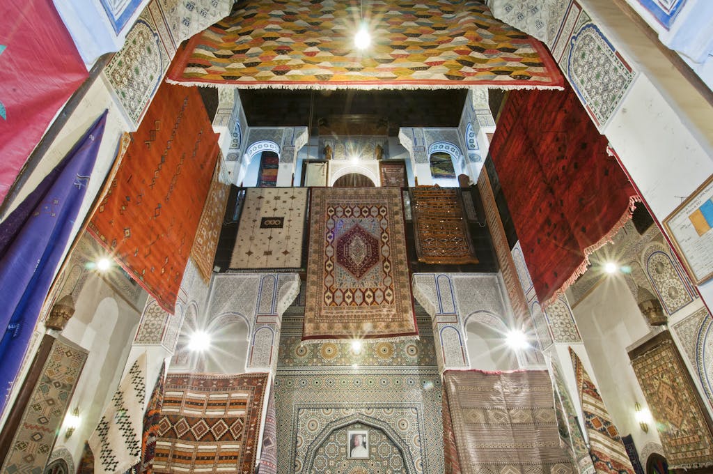 A captivating display of vibrant Moroccan rugs hanging in the historic Medina of Fès, Morocco.