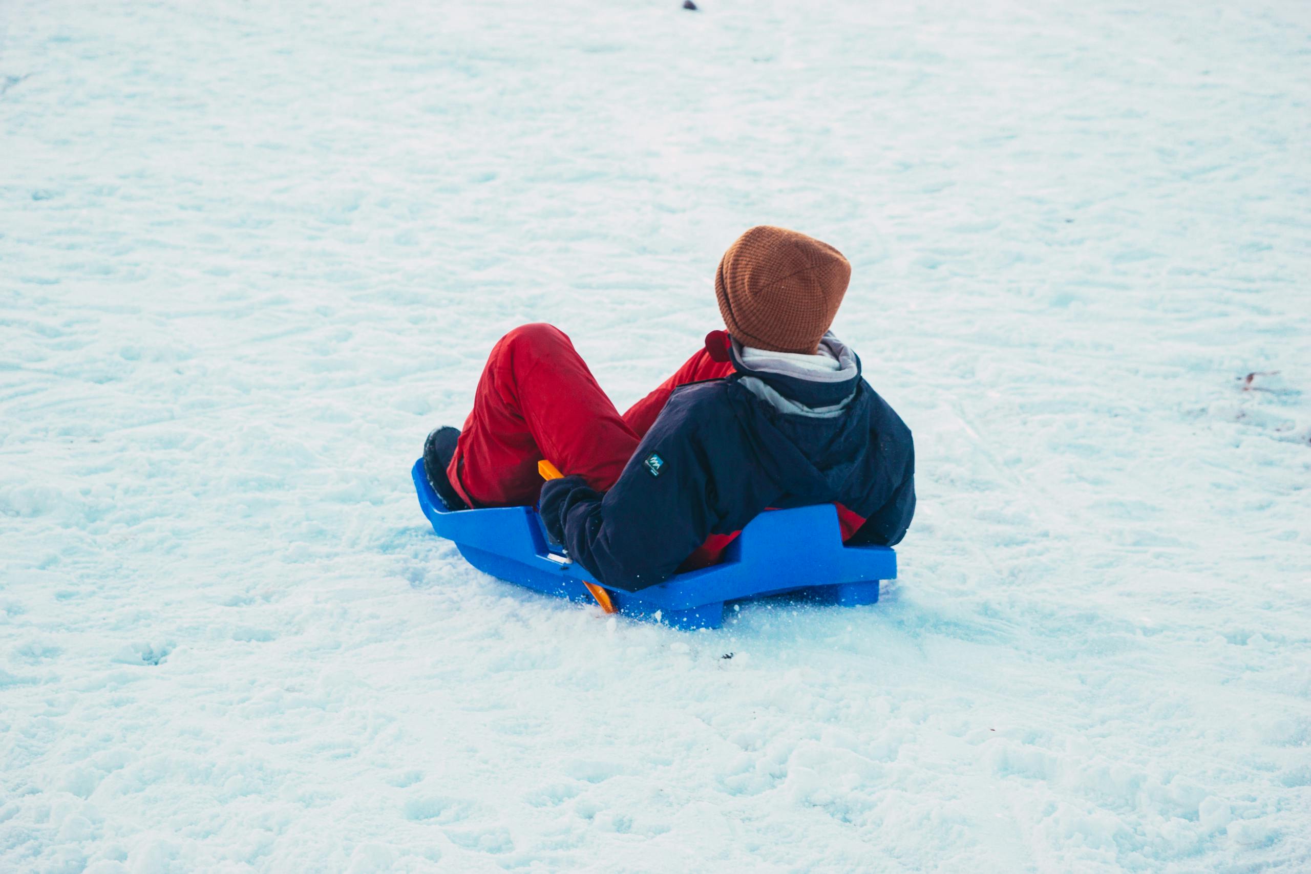 A person enjoys a wintry sledding adventure in the snowy landscapes of Oukaimeden, Morocco.