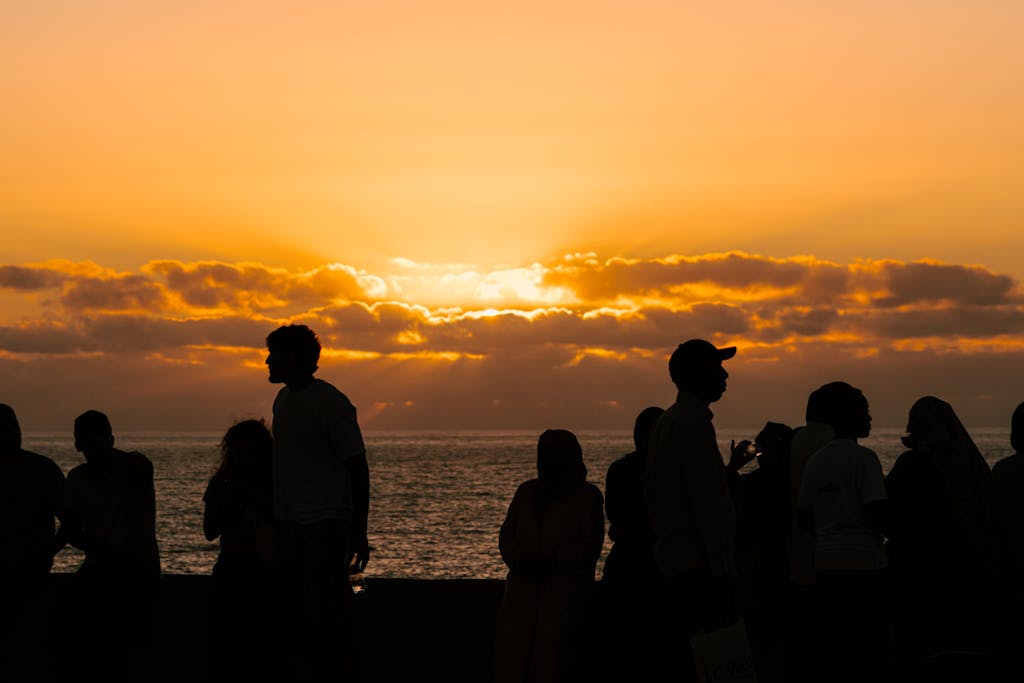 A vibrant sunset silhouette of people by the ocean in Rabat, capturing the lively atmosphere.