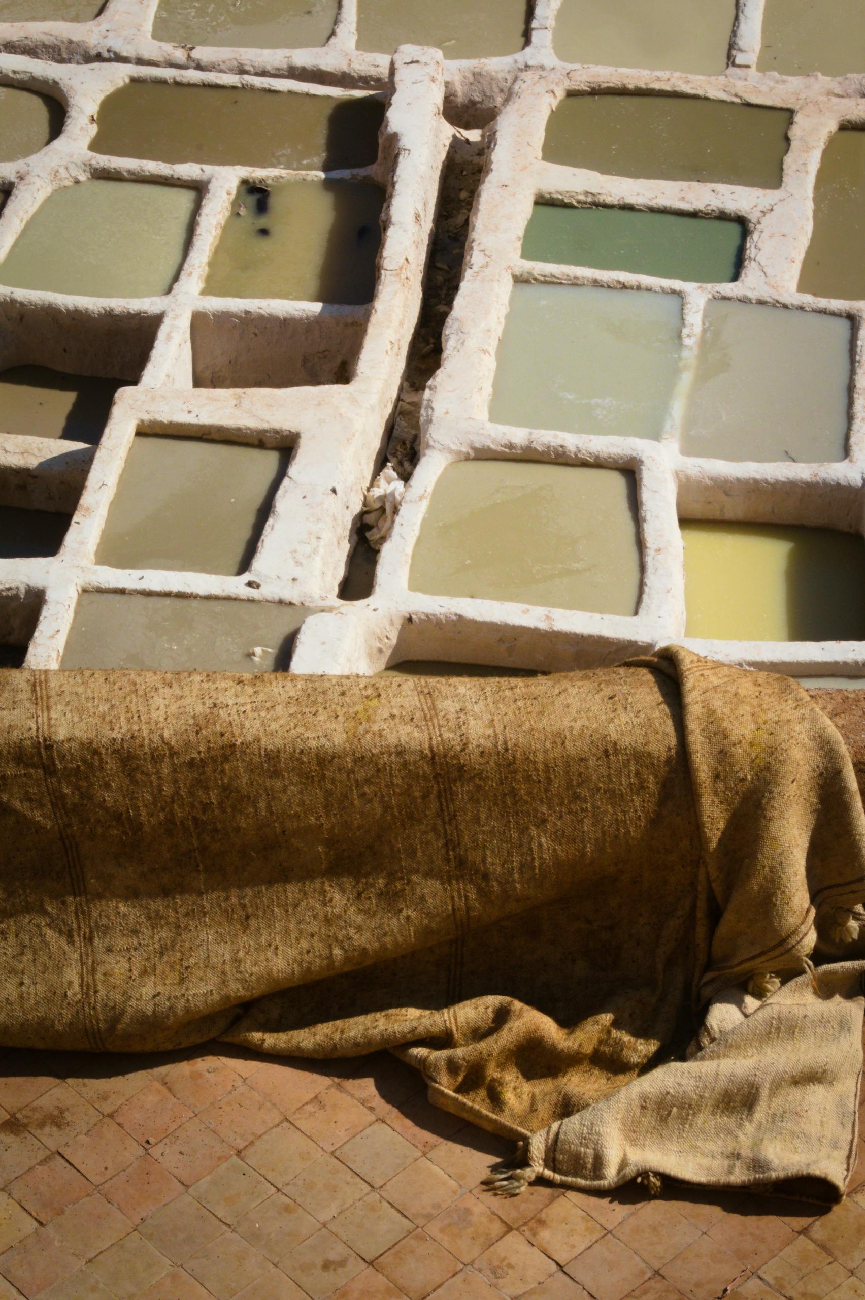 Aerial view of traditional leather dyeing pits in Fes, Morocco, showcasing vibrant colors.