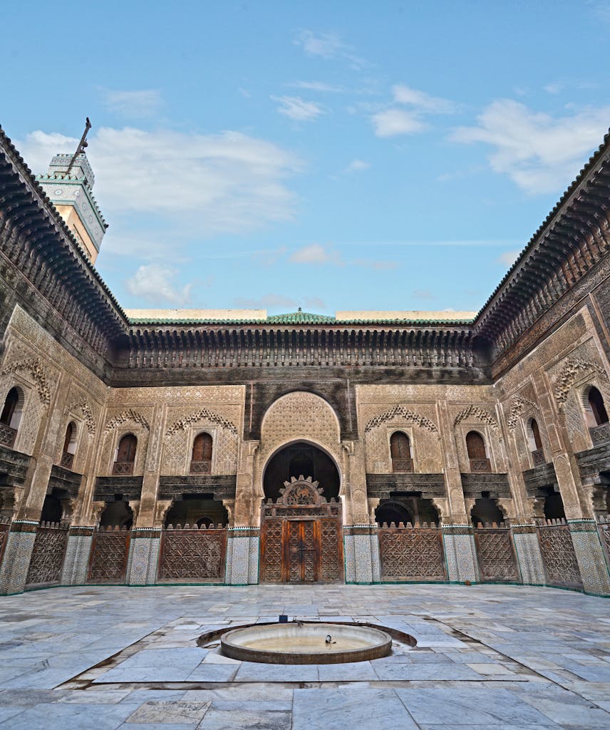 Beautifully ornate courtyard of a historic Medersa in Fès, showcasing intricate architecture.