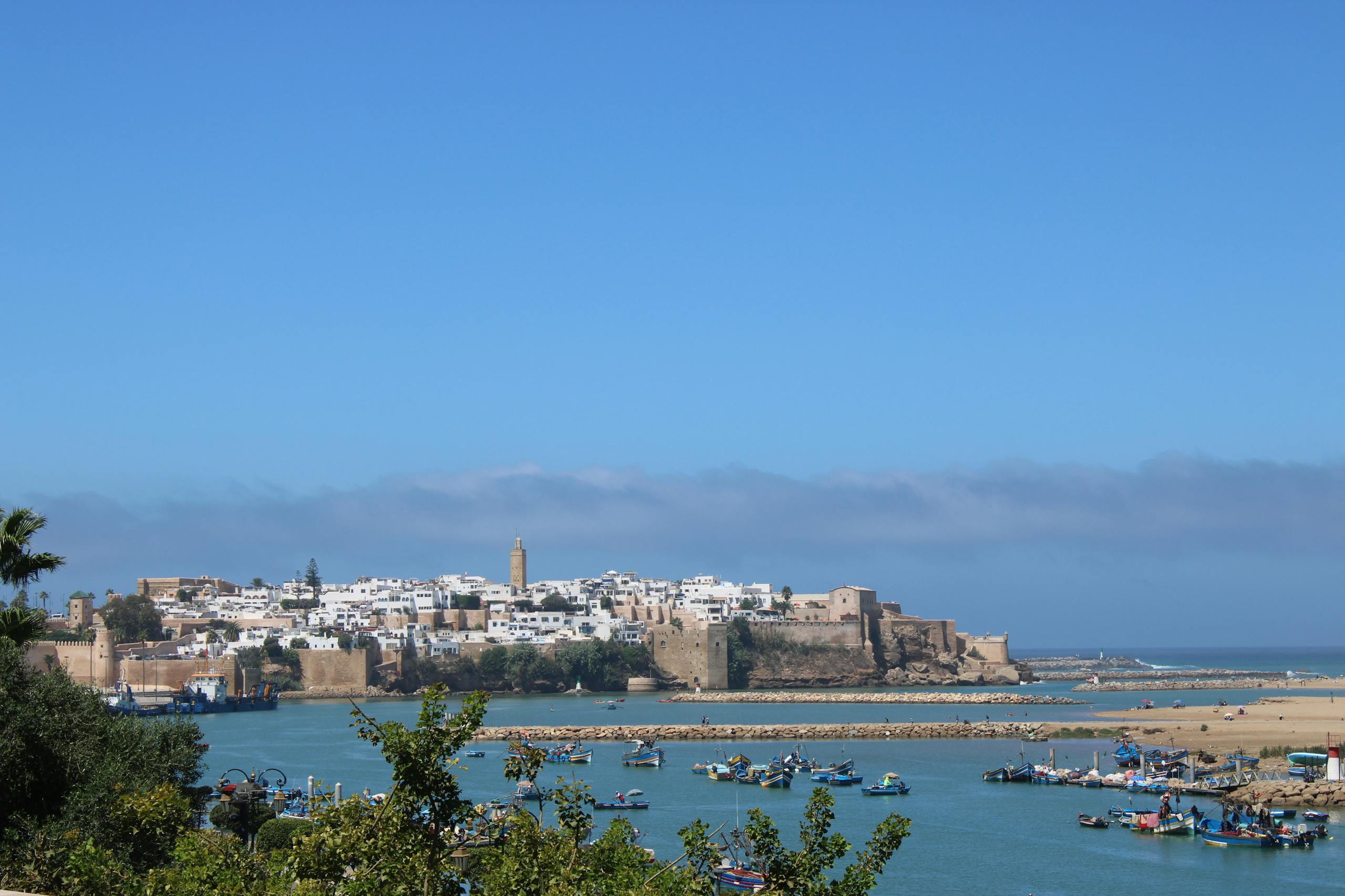 Discover the historic coastal skyline of Rabat, Morocco, with its vibrant blue waters and ancient architecture.